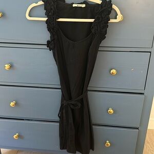 Black dress with waist tie and ruffle sleeves and neckline.